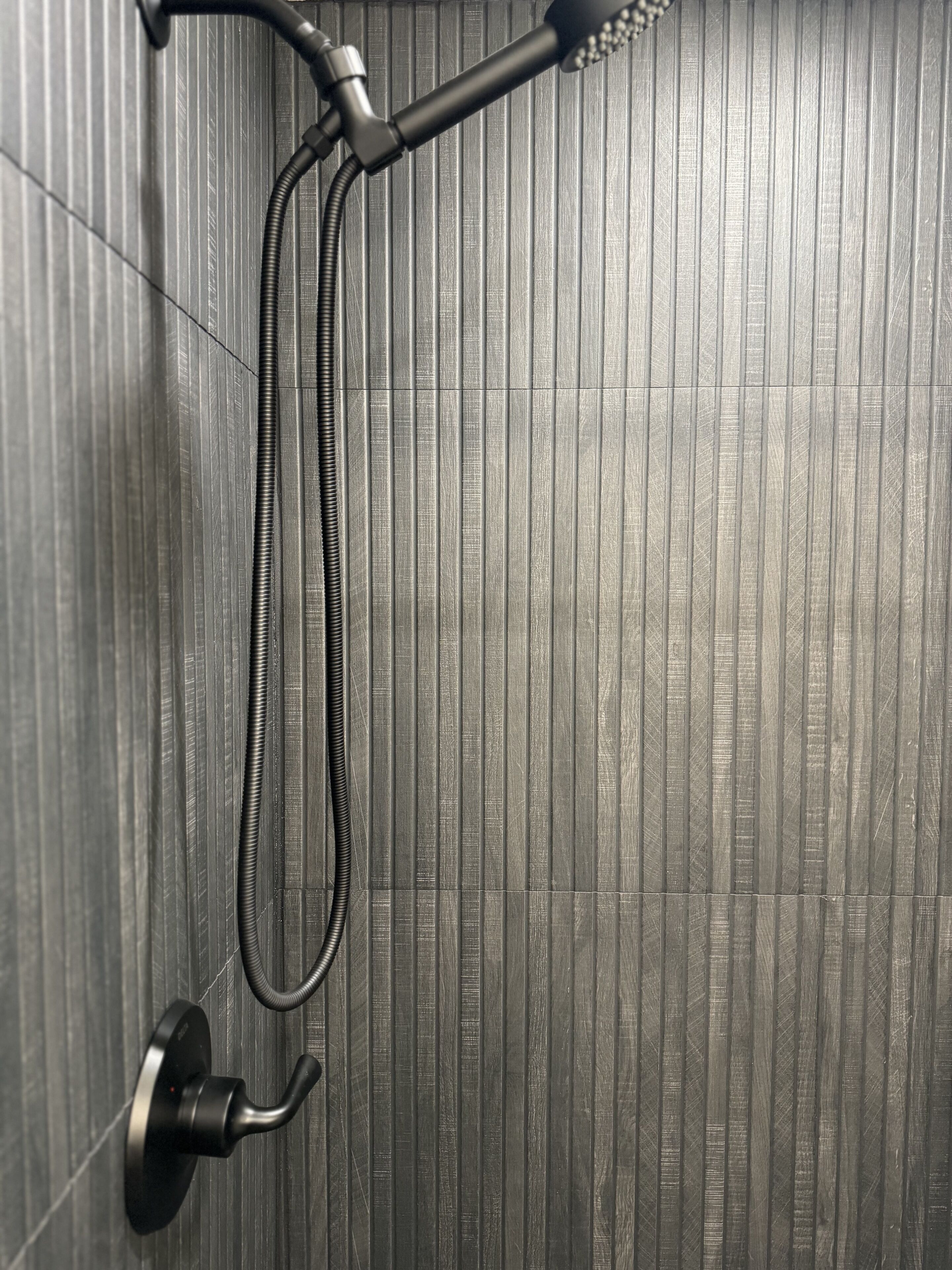 A shower with a handheld showerhead and a flexible hose.