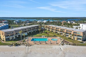 A hotel with a central pool, multiple balconies, and a view of the beach and water. - Ground Floor, Ocean views, steps from the sand, High end vacation home (Saint Augustine Beach Florida)
