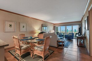 A hotel room with a dining area, a sofa, a TV, and a view of the city. - Ground Floor, Ocean views, steps from the sand, High end vacation home (Saint Augustine Beach Florida)