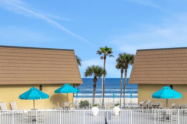 Oceanfront patio with vibrant umbrellas and pool access