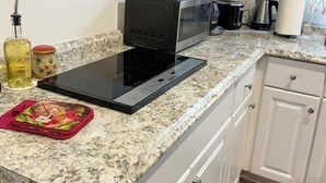 A kitchen with a built-in microwave, a coffee maker, and a kettle on the countertop. - Comfy & Inviting Poolside Casita near Bike Path (Los Angeles)
