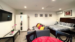 A bedroom with a bed, bedside table, lamp, and a television on the wall. - Comfy & Inviting Poolside Casita near Bike Path (Los Angeles)