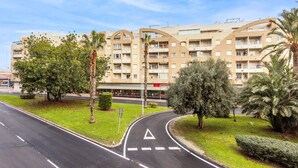 A multi-story hotel with a modern architectural design, featuring balconies and a central courtyard. - Cozy apartment in Torrevieja with swimming pool (Torrevieja)