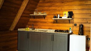 Una cucina con pareti in legno, un piano di lavoro in granito e un frigorifero.