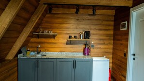 Una cucina con pareti in legno, un piano di lavoro in granito e un frigorifero bianco.