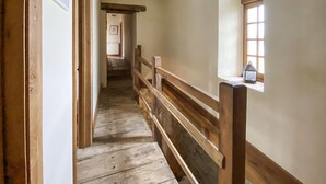 A narrow wooden staircase with a handrail, leading to a room with a window and a small lantern on the sill. - Lake front home in Chiché with house sea view (Chiché)
