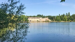 A large building by a calm lake with a clear sky. - Lake front home in Chiché with house sea view (Chiché)