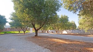 A gravel area with trees and a concrete wall. - Stunning home in Carovigno with WiFi (Carovigno)