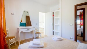 A hotel room with a bed, a desk with a mirror, a chair, and a wardrobe. - Stunning home in Carovigno with WiFi (Carovigno)