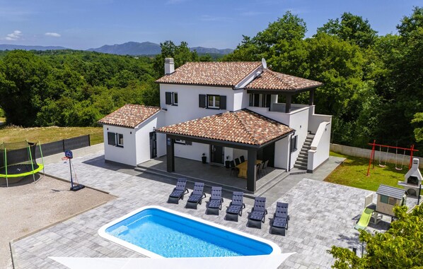 A modern two-story house with a swimming pool, outdoor seating, and a view of the mountains. - Beautiful home in Labin (Labin)