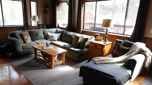 A cozy living room with a sofa, a coffee table, and a side table. - 3 BR+loft, fam. rm., 2 bth, lg deck, close to major ski areas, trails, history. (Soda Springs)