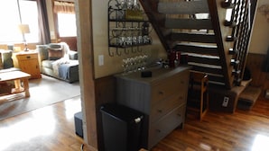 A wooden staircase with a metal railing, a wooden bench, a small table, and a wall-mounted shelf with glasses. - 3 BR+loft, fam. rm., 2 bth, lg deck, close to major ski areas, trails, history. (Soda Springs)