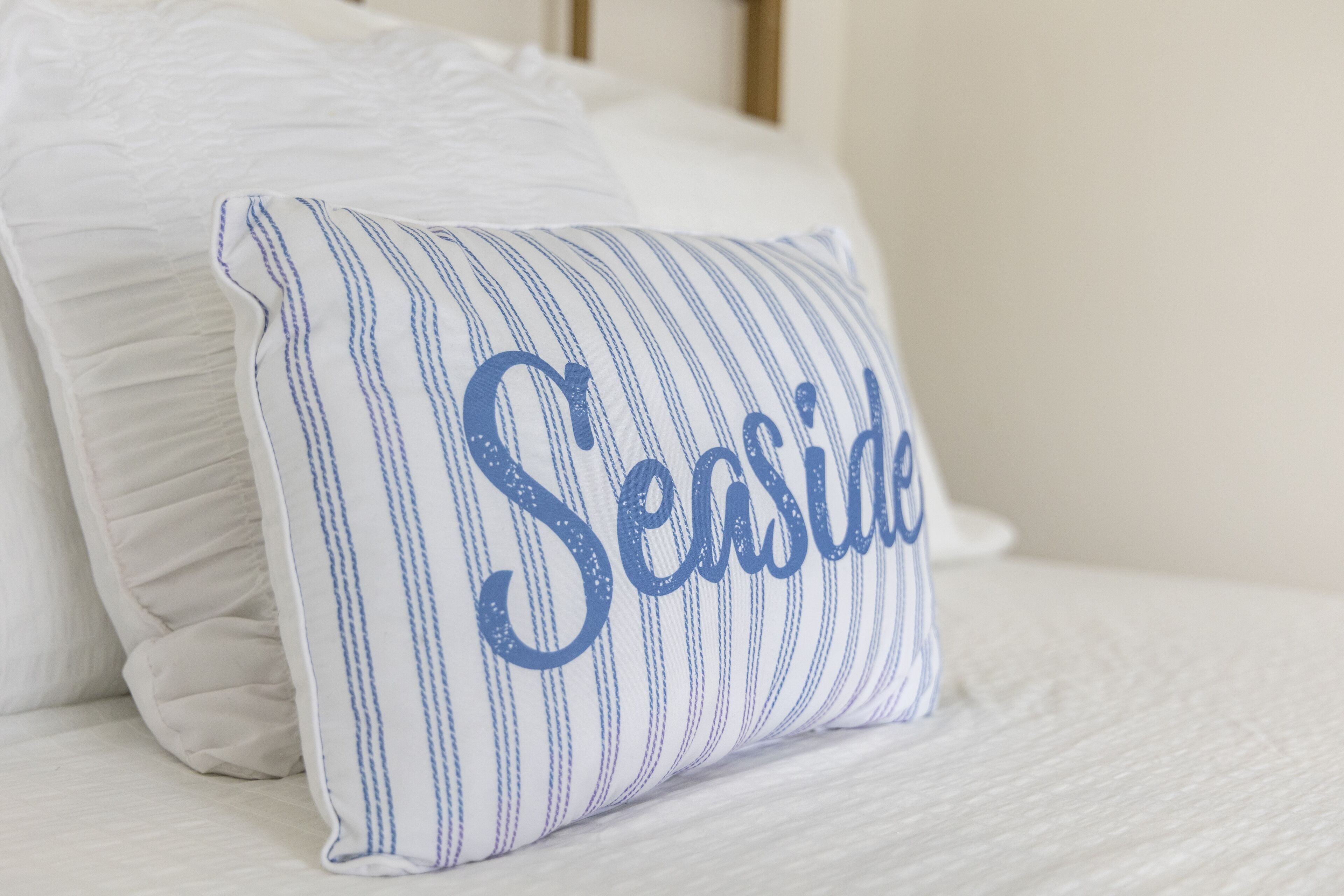 A pillow with the word "Seaside" embroidered on it.