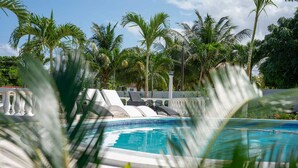 A swimming pool with lounge chairs and palm trees in the background. - Newly Renovated!! COCO PALMS - Exclusive villa with private pool/beach access.  (Mammee Bay, Mammee Bay Estates)