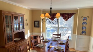 A dining room with a wooden table set for four, flanked by wooden cabinets with glass doors. - Saratoga retreat!  Great yard with inground pool.  4 miles from Racetrack. (Saratoga Springs)