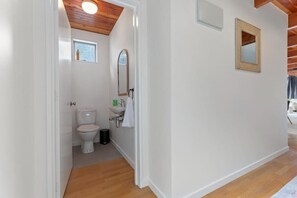 A compact bathroom with a toilet, sink, and mirror.