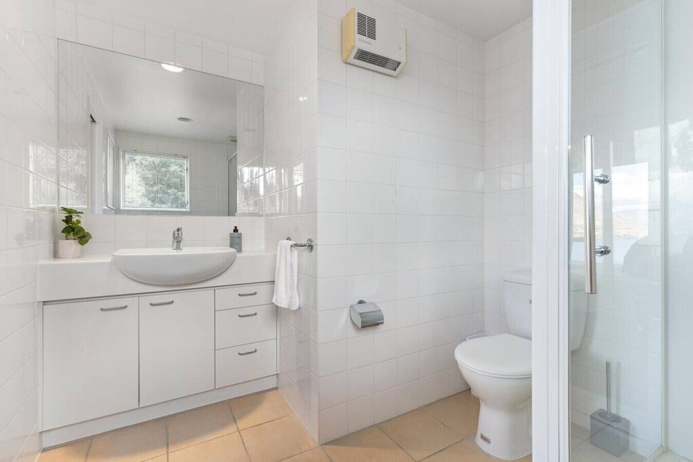 Ein modernes Badezimmer mit Waschbecken, Spiegel und Toilette.