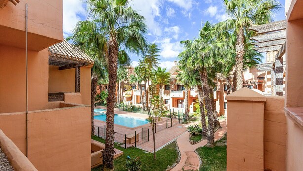 A resort with a swimming pool, palm trees, and a courtyard. - Amazing apartment in Los Alcázares (Los Alcázares)