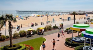 A beachside promenade with a pier in the background, bicycles, and umbrellas. - OBC - 3BR/3BA Penthouse - Oceanfront (Virginia Beach)
