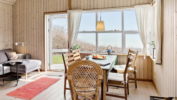 A cozy room with a dining table, chairs, and a view of the outdoors.