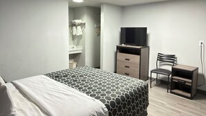 A bedroom with a bed, a desk, a chair, a television, and a wardrobe. - JAL COUNTRY INN (Jal)