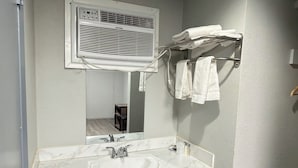 A bathroom with a marble sink, a mirror, a towel rack, and a trash bin. - JAL COUNTRY INN (Jal)