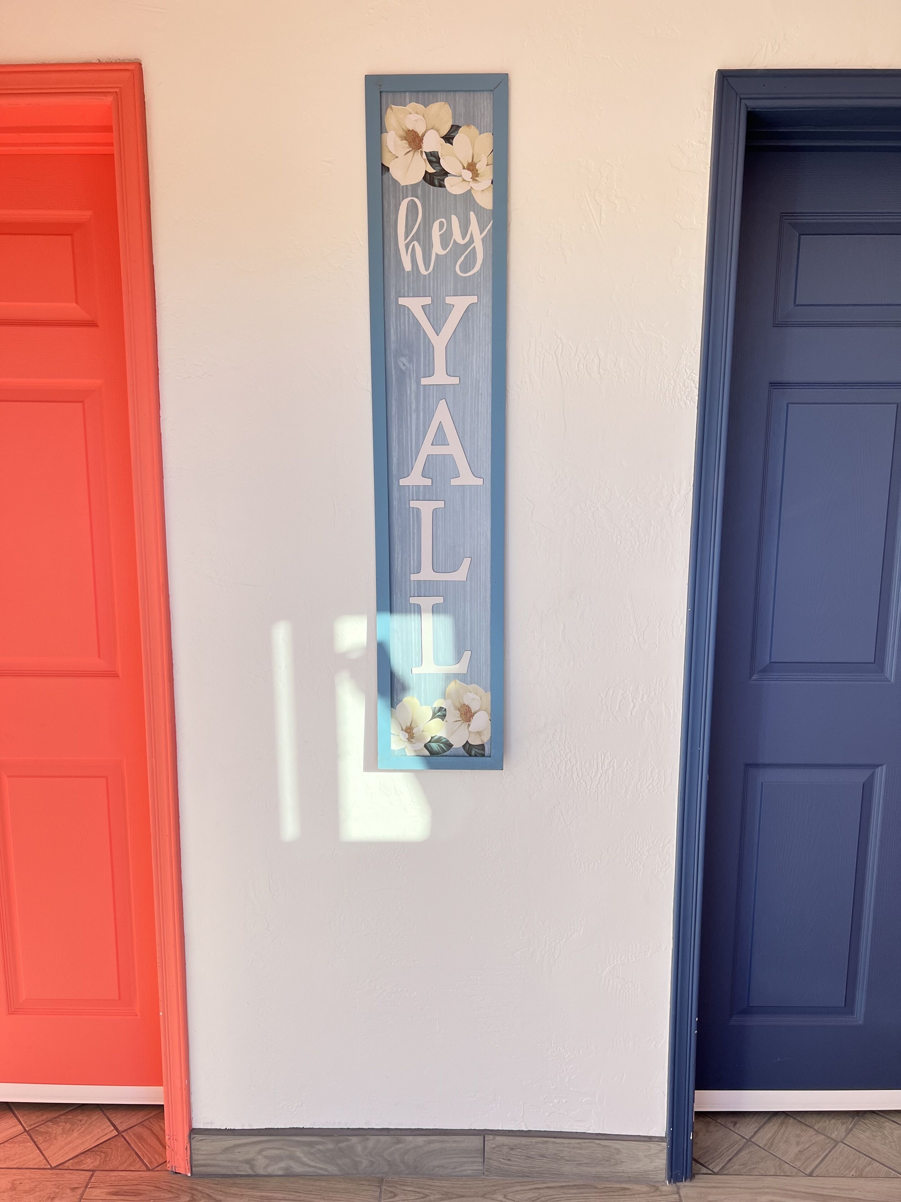 A hallway with a red door on the left and a blue door on the right.