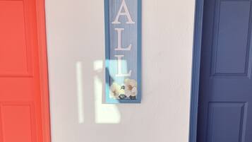 A hallway with a red door on the left and a blue door on the right.