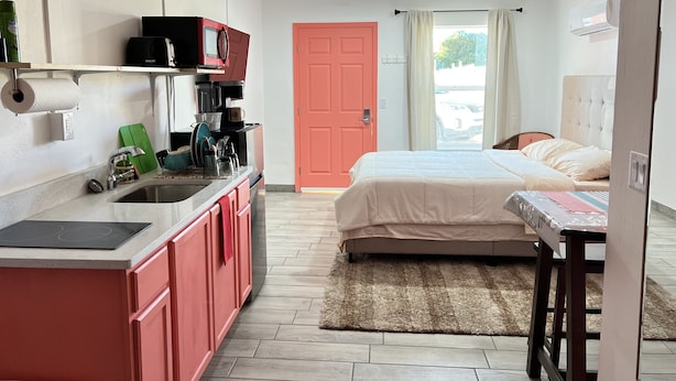 A compact hotel room with a kitchenette, a bed, and a view of the street. - Private Suite with Washer and Dryer, Kitchenette  and Enclosed Parking (Las Cruces)