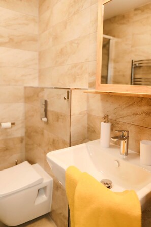 Een badkamer met een wit wastafel, een spiegel en een toilet.