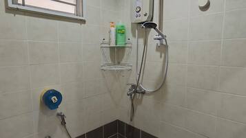 Un baño con ducha, inodoro, lavabo y ventana.