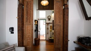 A wooden hallway with a rustic door, a clock, and a small table with a basket. - Hanuman Boutique Stay & Eatery (Hat Yai)