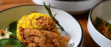 Una mesa con varios platos, incluyendo arroz amarillo, pollo frito y diferentes acompañamientos.