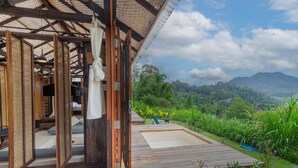 A wooden deck with a view of a lush landscape and a mountain in the distance. - Calidas Hill (Kintamani)