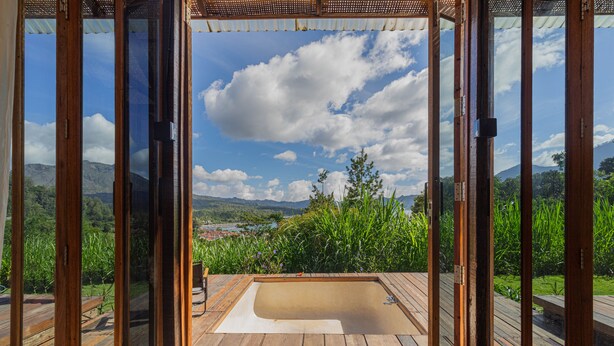 A wooden deck with a hot tub and a view of a mountainous landscape. - Calidas Hill (Kintamani)