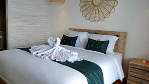 A neatly made bed with white linens, a green throw blanket, and decorative pillows. - The sagara villa (Penida Island)