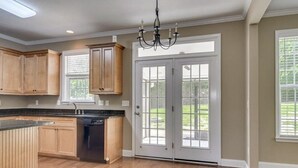 A kitchen with wooden cabinets, a dishwasher, and a double door with glass panels. - Wonderful 4B2.5B for Augusta Master Holiday (Evans)