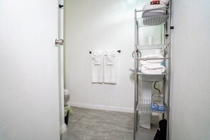 A bathroom with a toilet, a sink, a towel rack, and a towel shelf. - Cozy two bedroom house with a Million dollar view, Arroyo, Puerto Rico. (Arroyo)