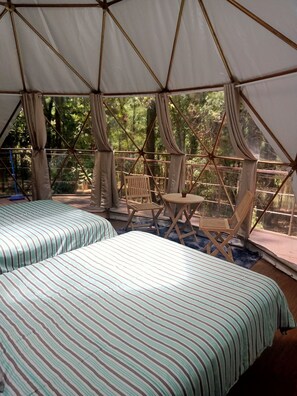 A tented accommodation with two beds, a small table, and a chair. - Glamping Don Delfis (Valle de Bravo)