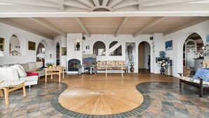 A spacious living area with a central wooden floor, a fireplace, and a dining table. - "Herlek" - 450m from the sea by Interhome (Aakirkeby)