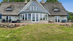 A large house with a thatched roof, a glass conservatory, and a stone foundation. - "Herlek" - 450m from the sea by Interhome (Aakirkeby)