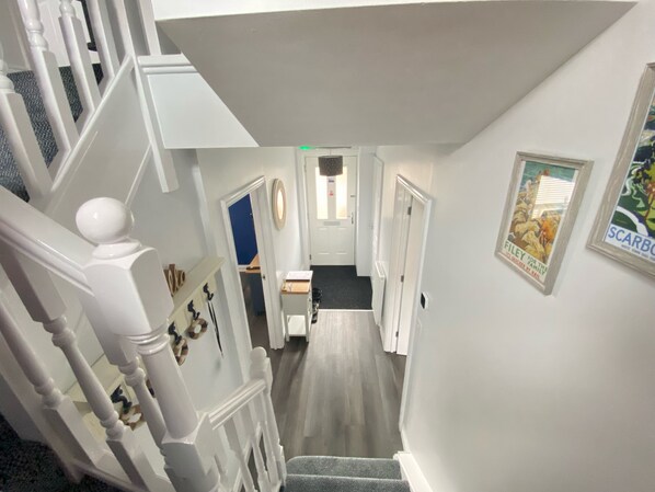 A staircase leading to a room with a door, a framed picture on the wall, and a carpeted floor. - Stunning Coastal Cottage - Sleeping 4 in 2 Bedrooms - Pool and Beach Access Included. (Filey)