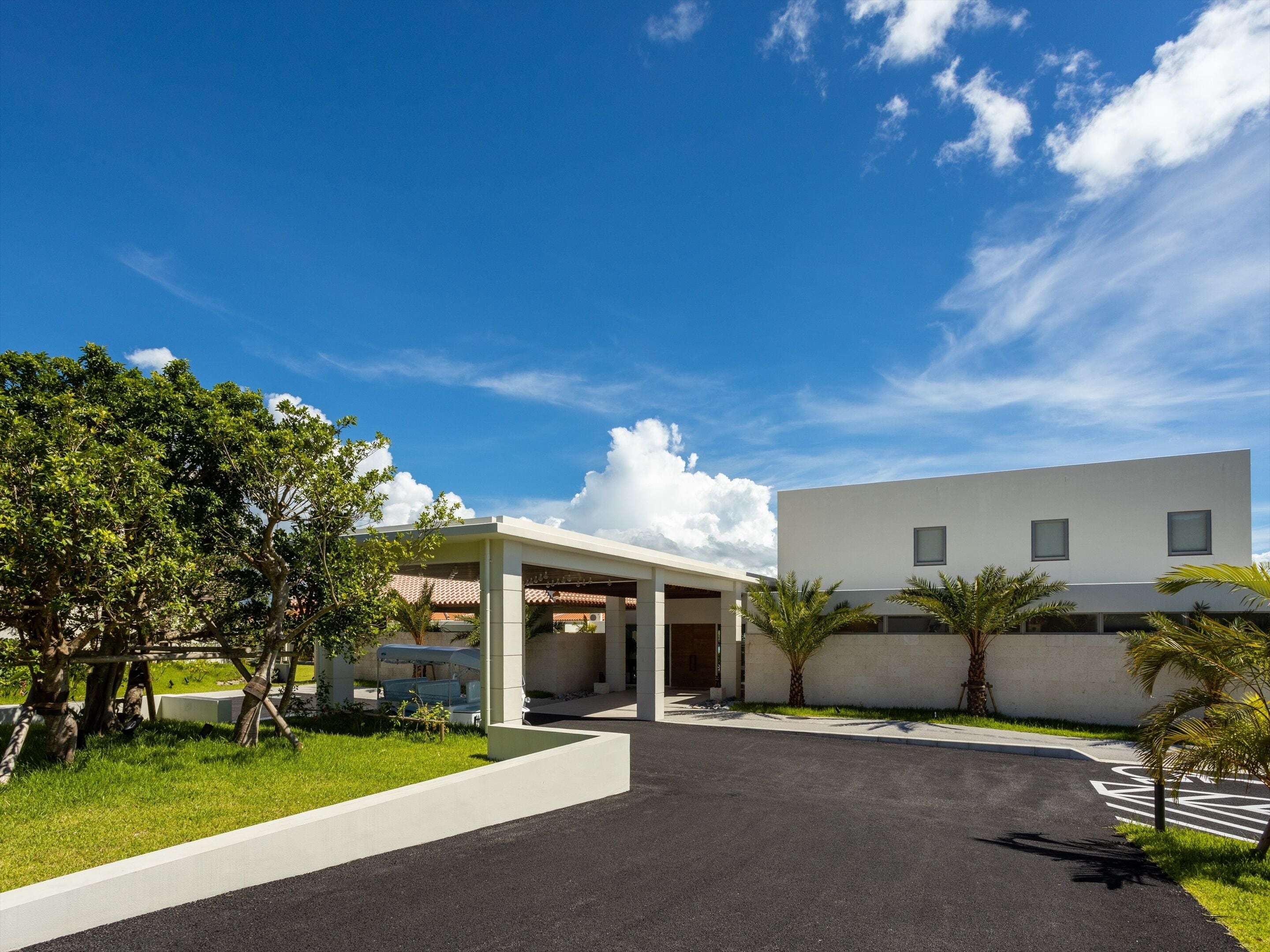 A modern building with a flat roof and a covered entrance.