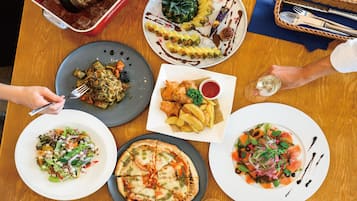 A table with various dishes, including pizza, salad, and a dessert with a pineapple.