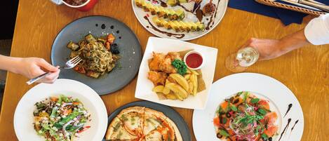 A table with various dishes, including pizza, salad, and a dessert with a pineapple.