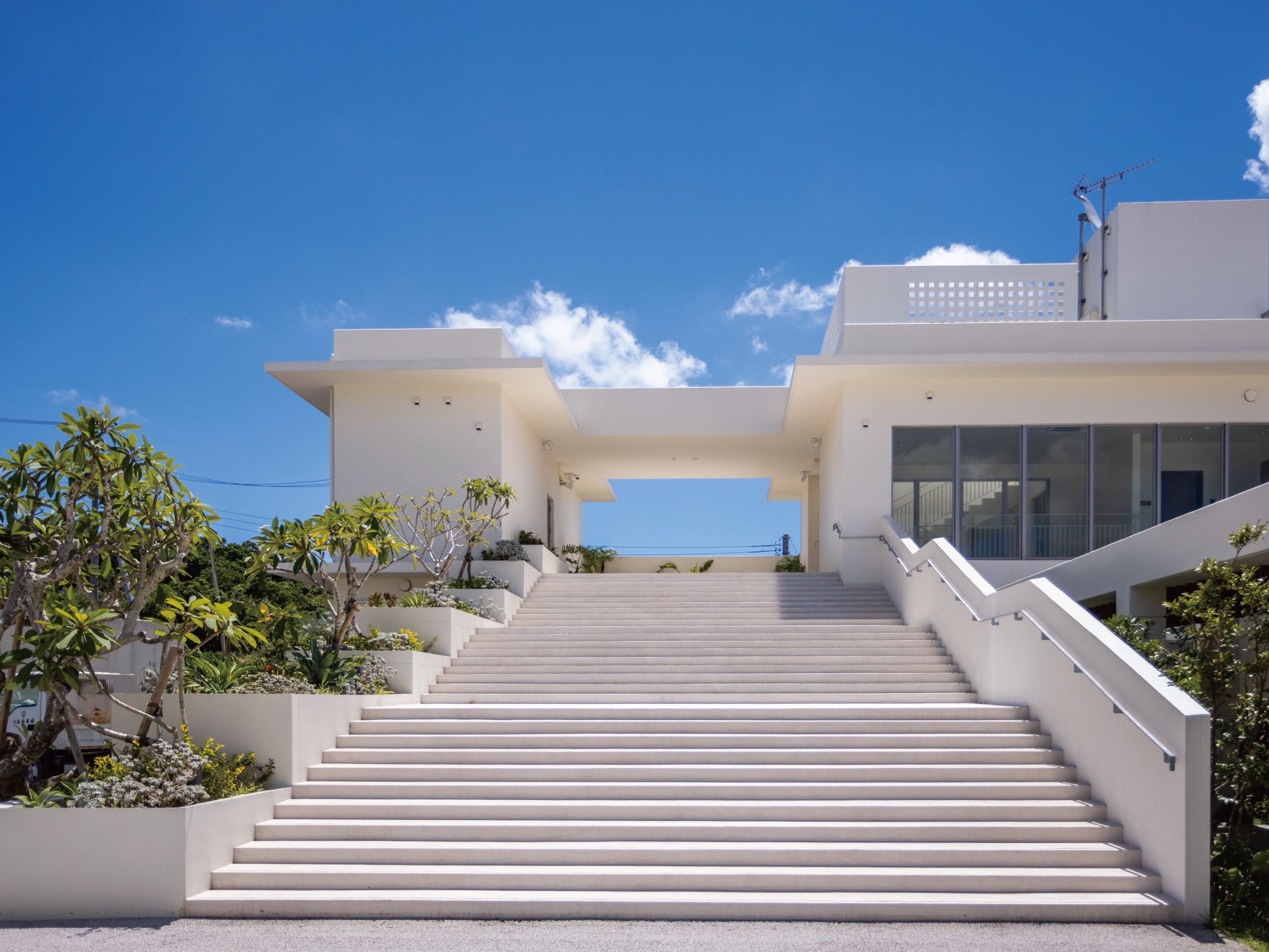 A modern building with a staircase leading to a flat roof.