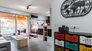Una sala de estar moderna con un ventanal grande, una obra de arte mural con un globo terráqueo y una colección de placas de automóvil antiguas.