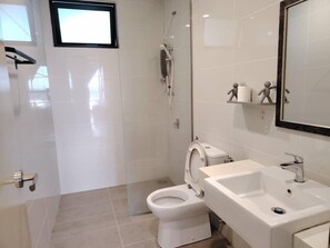 Ein modernes Badezimmer mit Toilette, Waschbecken und Dusche.