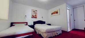 A bedroom with two single beds, a nightstand, a wall clock, and two posters.
