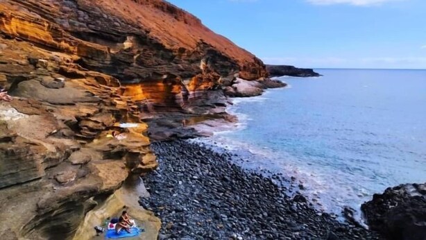 Un paisaje costero con acantilados rocosos y una playa de guijarros.